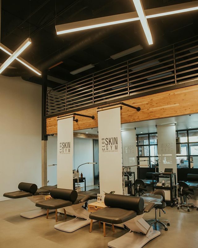 Inside a Club Skin Gym clinic: treatment beds under a warm wood ceiling