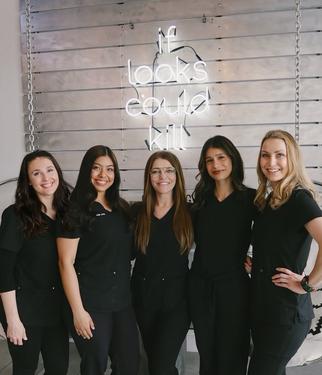 Five Club Skin Gym Face Trainers in black scrubs, smiling together in the clinic